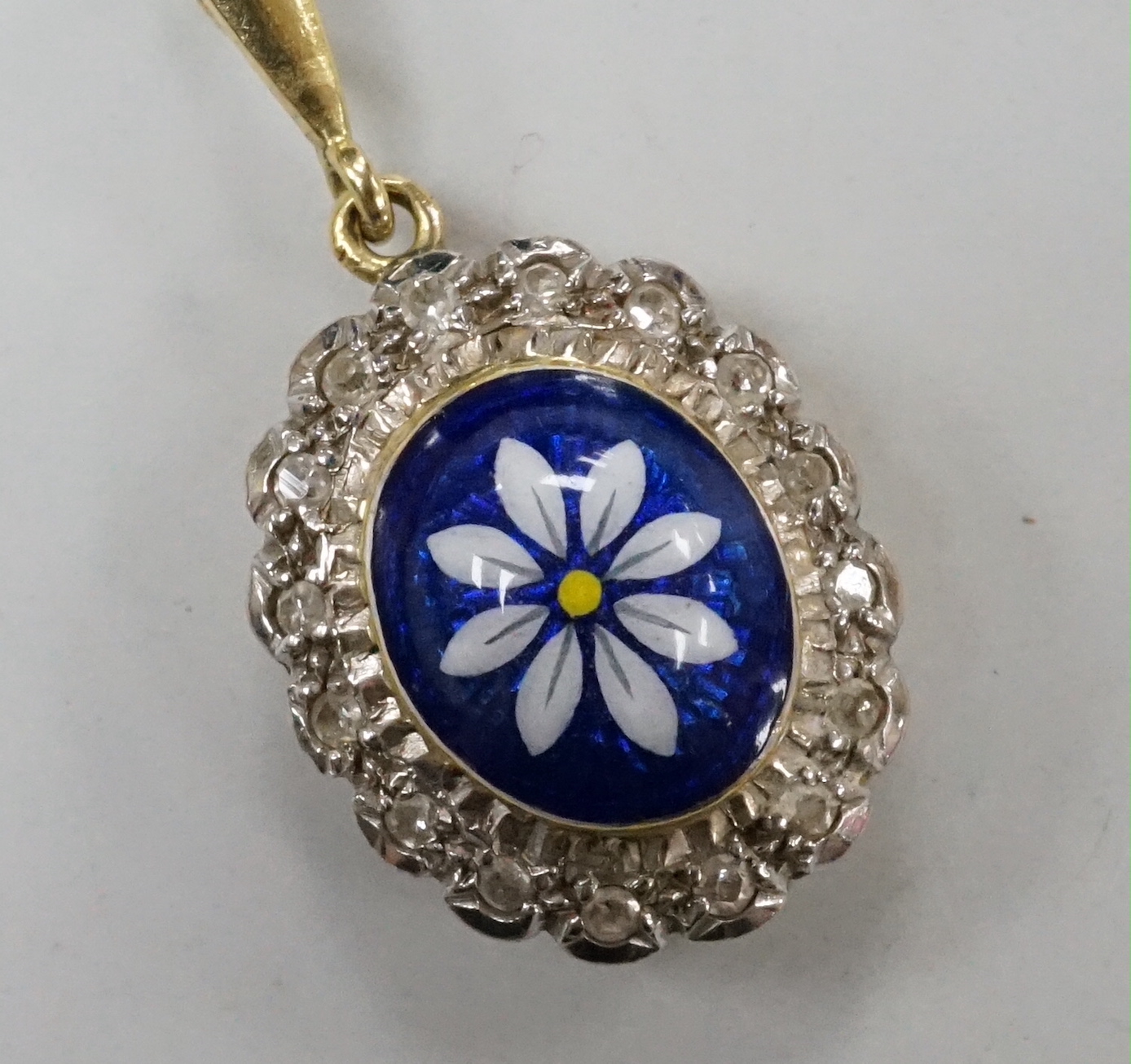 A modern 18ct gold, enamel and illusion set diamond chip oval cluster pendant, overall 30mm, gross weight 5.9 grams.